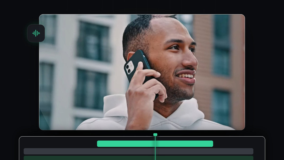 Smiling man talking on a smartphone in front of a brick building, used for the phone call voice tutorial in Premiere Pro